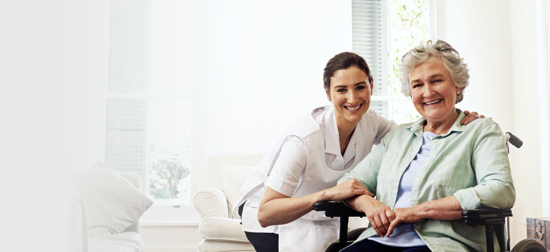 senior in wheelchair with her caregiver beside