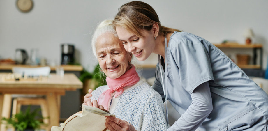 elderly embroidering with her caregiver 