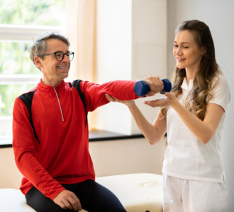 aide helping the adult man exercise
