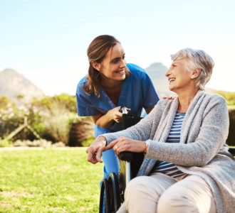 aide and senior woman smiling together