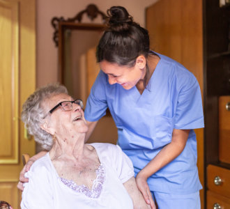 aide and senior woman smiling