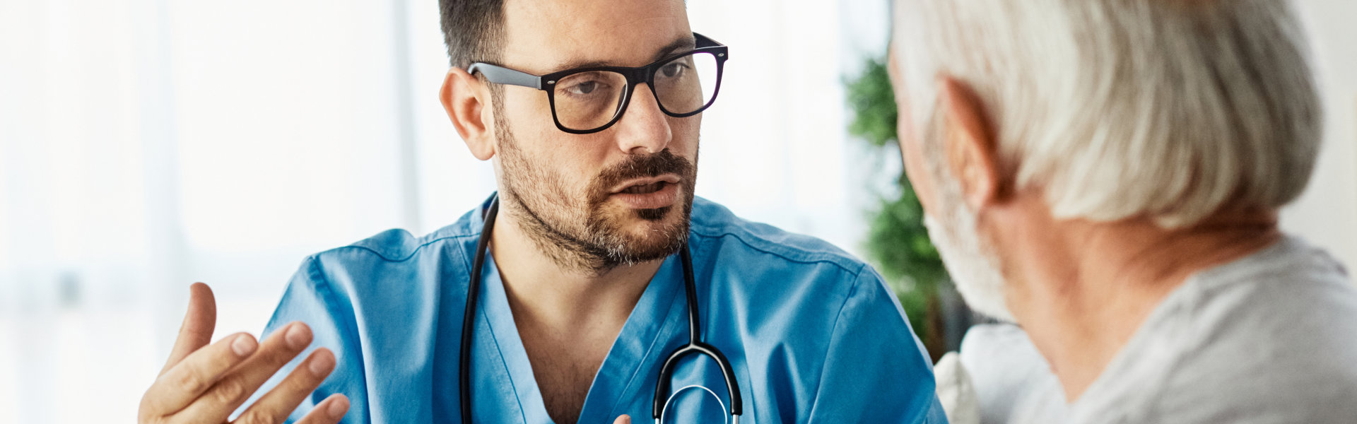 male caregiver having a conversation with the elderly