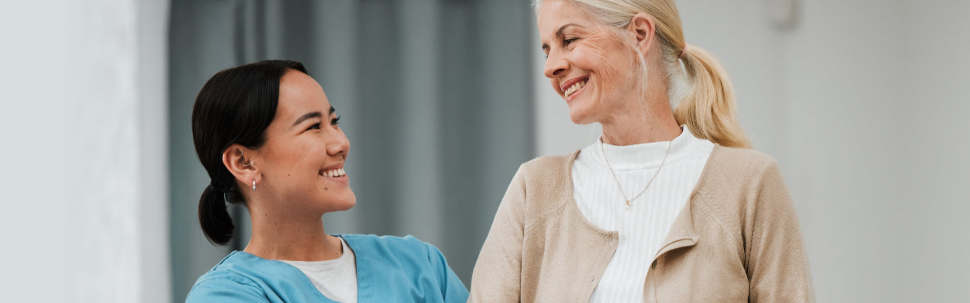 aide and senior woman smiling at each other