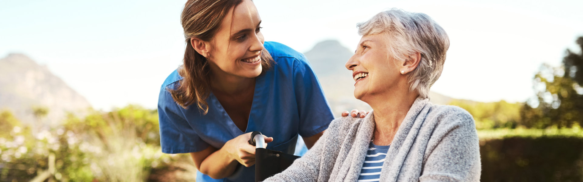 aide and senior woman smiling together